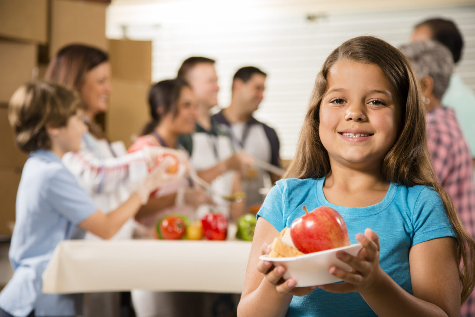 Girl holding fruit at community event.