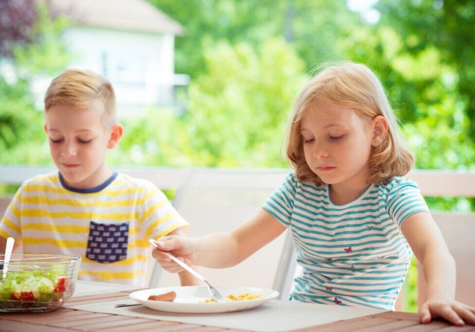 Children eating at an outdoor table.
